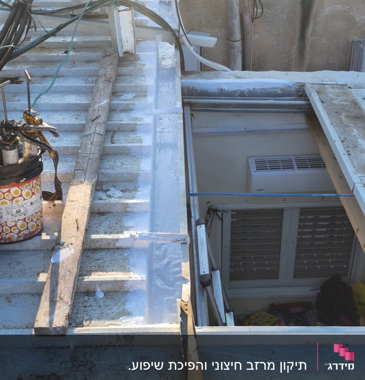 גג מתכת עם חומרים וכלים לתיקון ואיטום